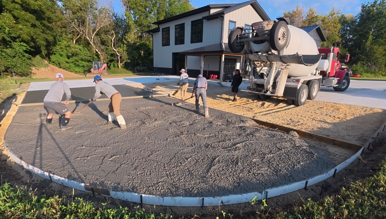 Commercial concrete crew pouring a large driveway with a ready-mix truck on site