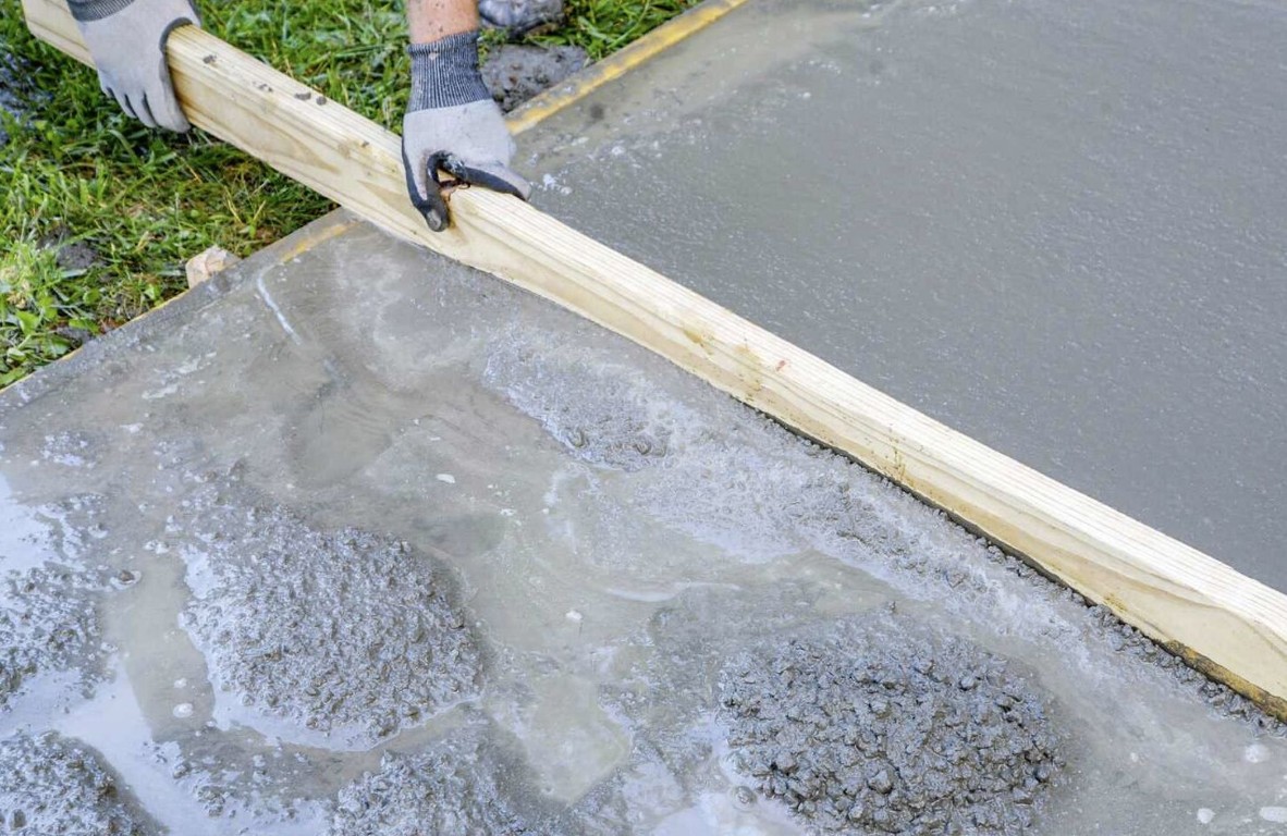 Concrete slab being screeded and leveled during residential foundation work
