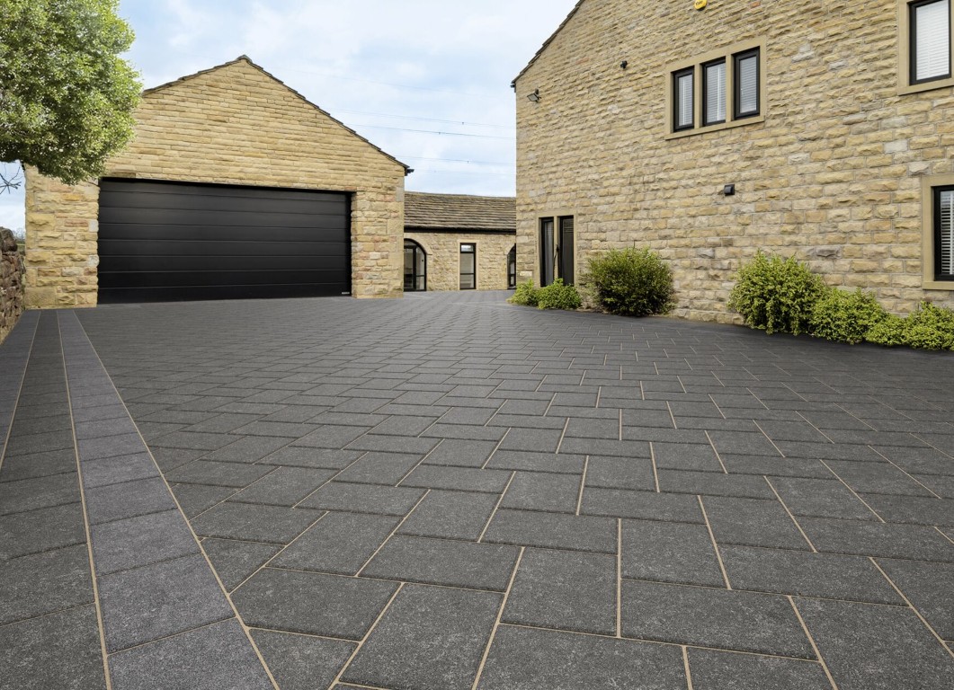 Stamped decorative concrete driveway with dark stone pattern in a residential property